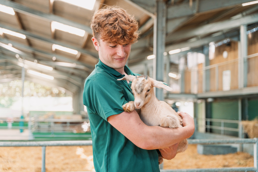 Staff holding a baby goat